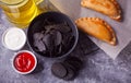 Mexican corn chips nachos and fried meat pies empanadas cheburek with dips. Black chips nachos for brutal men. Top view