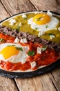 Mexican eggs huevos divorciados with Frijoles refritos, salsa roja and verde and cheese Queso Fresco close-up. Vertical Royalty Free Stock Photo