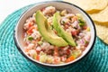 Mexican fish ceviche with avocado on white background