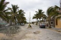 Mexican fishing village street during the rainy season with cars parked along the sides and bag of garbage in the middle of the st Royalty Free Stock Photo