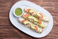 Mexican flutes, golden tacos. Traditional Mexican food. Traditional Mexican tacos with tomato, avocado and green hot sauce. Gourme Royalty Free Stock Photo