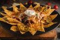 Mexican food background of chicken tortilla nachos in black dish in dark tone, selective focused