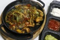 Mexican food, chicken fajitas serving on a hot smoking sizzling plate with sour cream, avocado guacamole, tomato salsa and Royalty Free Stock Photo