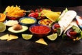 Mexican food, including tacos, guacamole, nachos and pepper on rustic table Royalty Free Stock Photo