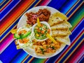 Mexican food mix colorful background, guacamole, cochinita pibil, flautas and quesadilla. Royalty Free Stock Photo