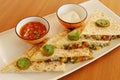 Mexican food quesadilla, spicy cooked chicken and vegetable stuffed in tortilla bread with cheese, guacamole, tomato salsa and Royalty Free Stock Photo