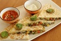Mexican food quesadilla, spicy cooked chicken and vegetable stuffed in tortilla bread with cheese, guacamole, tomato salsa and Royalty Free Stock Photo