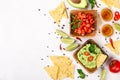 Mexican food selection: sauce guacamole, salsa, chips and tequila shots with lime on white background Royalty Free Stock Photo