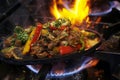 mexican food smoking chicken and beef fajitas on sizzling plate with fire and smoke Royalty Free Stock Photo