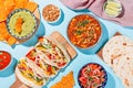Mexican food table with traditional dishes. Chili con carne, tacos, tomato salsa, corn chips with guacamole. Mexican feast in hard Royalty Free Stock Photo