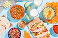 Mexican food table with traditional dishes. Chili con carne, tacos, tomato salsa, corn chips with guacamole. Mexican feast in hard Royalty Free Stock Photo