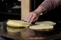 Mexican fresh corn tortillas being cooked on a traditional `comal`