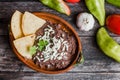 Mexican fried beans called Frijoles Refritos, plate of black beans on a wooden table in Mexico Royalty Free Stock Photo