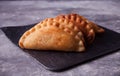 Mexican fried meat pies empanadas cheburek on the black plate on the concrete background