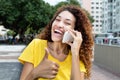 Mexican girl at phone showing thumb outdoor in city Royalty Free Stock Photo