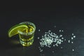 Mexican Gold Tequila shot with lime and salt on black stone table surface Royalty Free Stock Photo