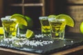 Mexican Gold Tequila shot with lime and salt on black stone table surface Royalty Free Stock Photo