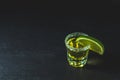 Mexican Gold Tequila shot with lime and salt on black stone table surface Royalty Free Stock Photo