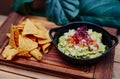 Mexican guacamole with nachos chips on wooden board Royalty Free Stock Photo