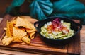 Mexican guacamole with nachos chips on wooden board Royalty Free Stock Photo