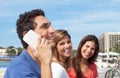 Mexican guy laughing at phone with girlfriends in the background Royalty Free Stock Photo