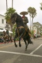 Mexican horseback riders trot along during the opening day parade down State Street of Old Spanish Days Fiesta held every August Royalty Free Stock Photo