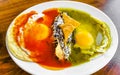 Mexican huevos divorciados fried eggs black beans nachos on plate