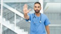 Mexican male nurse or doctor with beard and stethoscope gesturing stop