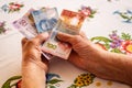 Mexican money, a pensioner holds several pesos banknotes in her hand, Financial problems of seniors, low pensions in Mexico