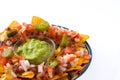 Mexican nachos with beef, guacamole, cheese sauce, peppers, tomato and onion in plate isolated Royalty Free Stock Photo