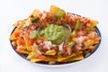 Mexican nachos with beef, guacamole, cheese sauce, peppers, tomato and onion in plate isolated Royalty Free Stock Photo