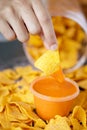 Mexican nachos dip into a sauce Royalty Free Stock Photo