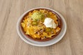 Mexican nachos with guacamole, cream cheese, beans and cheese gratin ready to gobble