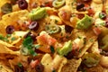 Mexican nachos tortilla chips with olives, jalapeno, guacamole, tomatoes salsa and cheese dip. close up Royalty Free Stock Photo