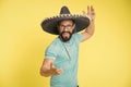 Mexican party concept. Man cheerful happy face in sombrero hat celebrating yellow background. Guy with beard looks Royalty Free Stock Photo