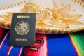 Mexican passport, mariachi hat and small car on colorful serape.