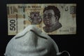 The 500 Mexican pesos bill is next to the mouthpiece.