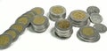 Mexican pesos, stacked coins of various denominations on white background