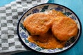 Mexican potato patties with red sauce on blue background