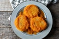 Mexican potato patties with red sauce on wooden background