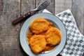 Mexican potato patties with red sauce on wooden background