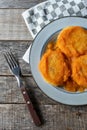 Mexican potato patties with red sauce on wooden background