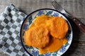 Mexican potato patties with red sauce on wooden background