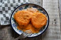 Mexican potato patties with red sauce on wooden background