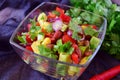Mexican salad with tomato, avocado, red beans, corn, paprika, red onion, lemon, chili, olive oil, parsley