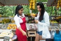 Mexican saleswoman presenting fruits to a client on farmers market