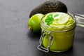 Mexican sauce guacamole in a jar on black stone background Royalty Free Stock Photo