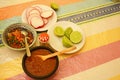 Mexican sauces/limes/radishes on table