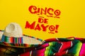 Mexican Serape blanket and sombrero on yellow background with Cinco de Mayo.