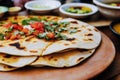 Mexican snack Quesadillas on grill with cheese meat and vegetables on wooden board